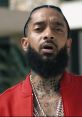 Nipsey Hussle with an intense expression, showcasing his distinctive tattoos and red attire, representing his unique style.