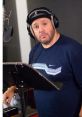 Kevin James as Otis in a recording studio, ready to voice his animated character with headphones on. Creative energy captured.