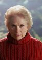Pamela Voorhees, iconic horror figure, stares intensely, wearing a red sweater, embodying maternal vengeance.