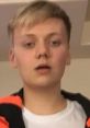 Niall, also known as Pyrocynical, with a neutral expression and wearing a colorful hoodie indoors.