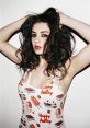 Charli XCX showcases a playful style in a vibrant, food-themed outfit, exuding confidence and charisma.