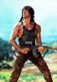 Rambo, portrayed by Sylvester Stallone, stands in a dramatic pose, holding an assault rifle in a rugged, outdoor setting.