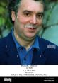 Michael Angelis, renowned actor, smiling in a blue jacket, captured in 1993, showcasing his engaging personality.