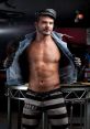 Portrait of a muscular man in a denim jacket and striped pants, embodying confidence and edgy style in a nightlife setting.