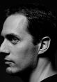 Profile of a male artist, capturing the essence of Grand Corps Malade's poetic expression in a striking monochrome setting.