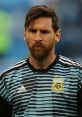 Lionel Messi in a blue and black striped jersey, focused and determined on the field, representing Argentina's national team.