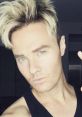 art Baker showcasing his signature hairstyle and striking green eyes in a casual selfie.
