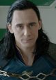 Loki with dark hair and serious expression, wearing a blue costume, showcasing his iconic look and charm from the series.