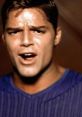 Ricky Martin singing passionately in a vibrant blue shirt, showcasing his iconic charisma and musical talent.