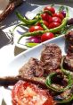 Delicious karışık kebab platter featuring grilled meat, fresh tomatoes, and green peppers, perfect for a savory meal.
