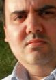 Close-up portrait of Giuseppe Simone, showcasing intense expression and focused gaze against a natural background.