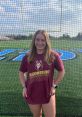 Katelyn M. Folweiler poses in a Bloomsburg University t-shirt on a sports field, showcasing school spirit and athletic pride.