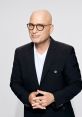 Howie Mandel smiles confidently in a stylish black suit, showcasing his signature charm and personality.