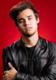 Stylish young man in a black leather jacket poses confidently against a bold red background. Ideal for fashion and lifestyle themes.