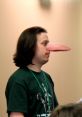Man with exaggerated nose and long hair, wearing a green shirt, captured at a convention or event. Spoonyone fan moment.