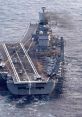 INS naval aircraft carrier sailing through the ocean, showcasing military helicopters on the flight deck and smoke from the chimney.