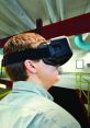 Person using a VR headset in a futuristic industrial setting, showcasing immersive technology and virtual experiences.