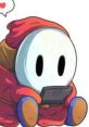 Saselandia character in a red hooded cloak, playing a handheld game, exuding a playful and cozy vibe.