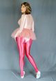 A person wearing a shiny pink bodysuit and leggings, completing a playful sissy aesthetic. Tutu adds a whimsical touch.