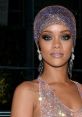 Rihanna showcases stunning beauty with a dazzling crystal headwrap and glamorous makeup at a red carpet event.