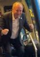 Muharrem İnce enthusiastically boarding a bus, showcasing his energetic personality and approachability.