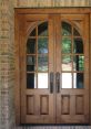 Elegant wooden double doors with arched tops and glass panes, framed by a classic brick entrance. Enhance your home's curb appeal.