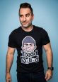 Man wearing a black Todd Squad t-shirt with cartoon graphic, posing against a light blue background. Fun and playful style.