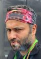 ChefMali showcasing a confident look with a colorful headband and cigar, capturing a bold culinary personality.