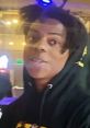 IShowSpeed streamer smiling, wearing a black hoodie, with colorful lights in the background, showcasing vibrant gaming vibe.
