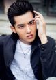 Yifan Wu striking a pose with sleek hairstyle and stylish outfit, showcasing modern fashion and charisma.