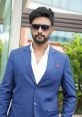 Stylish man in a blue suit with sunglasses, exuding confidence and modern elegance outdoors. Perfect for fashion inspiration.