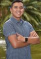 Johan Barbosa smiling confidently, arms crossed, with a lush green background reflecting a serene outdoor setting.