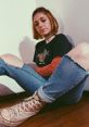 Casual style portrait of a young woman with short hair, wearing a graphic tee and ripped jeans, exuding laid-back vibes.