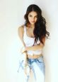 Daniela Campos posing casually in a white top and jeans, showcasing her elegant style and natural beauty.