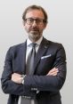 Professional portrait of Marcello Sarti, showcasing a confident pose in a tailored suit and stylish accessories.