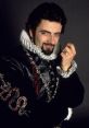 Rowan Atkinson as Edmund Blackadder in a historical costume, showcasing a mischievous expression and elaborate attire.