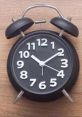 Classic black alarm clock displaying 10:10, symbolizing punctuality and office hours management.