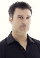 Close-up portrait of Joe, the Narrator, showcasing his thoughtful expression and stylish black shirt against a light background.