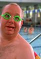 Man in green swim goggles at a pool, showcasing a humorous moment from "The Ringer," a film about unique challenges.