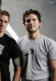 Two band members pose confidently, showcasing their unique style while promoting Nickelback's image and music.