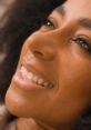 Close-up of a smiling woman with curly hair, showcasing joy and beauty, relevant to Adri in Afrikaans South Africa.