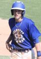Baseball player Jacob in a blue uniform with a chain necklace, focused on the field during a Palmetto Games event.