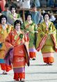 Women in vibrant traditional Aoi costumes participate in a Japanese festival, showcasing rich cultural heritage and elegance.