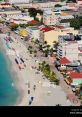Aerial view of a vibrant beach with colorful loungers and palm trees, showcasing the lively atmosphere of Maarten.