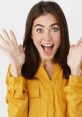 Cheerful young woman in a yellow blouse expressing excitement with raised hands and a wide smile. Perfect for joyful moments.